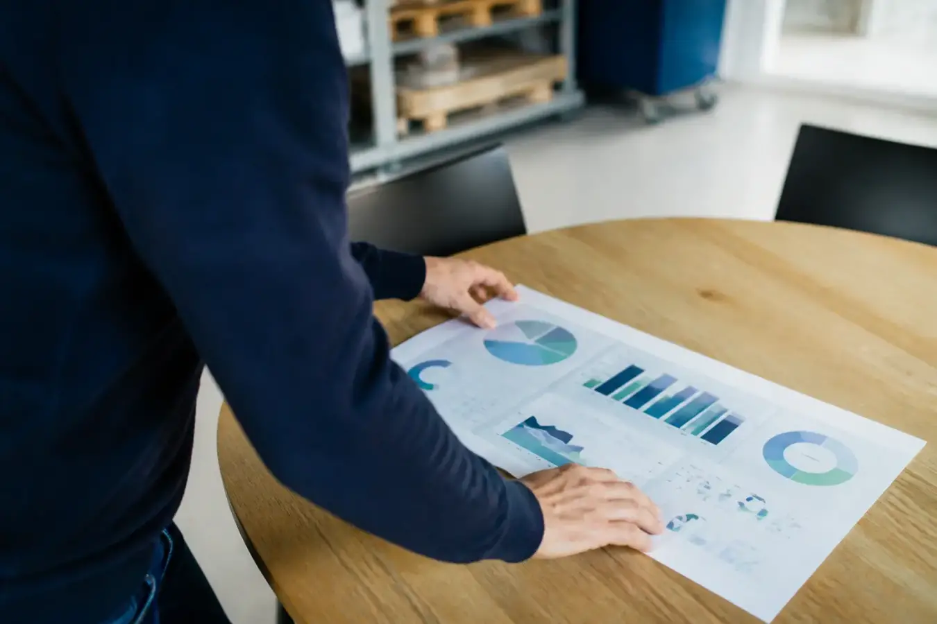 Dirigeant de PME devant un tableau de bord imprimé sur une table de réunion