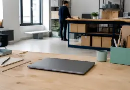 Ordinateur portable posé sur un bureau de travail, écran fermé, dans un espace de bureau sobre