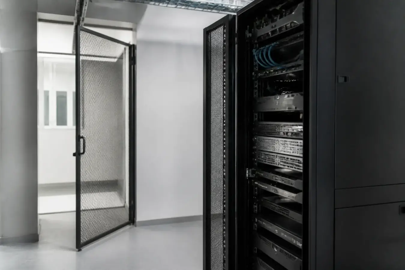 Salle technique d’une petite entreprise avec un serveur et des câbles réseau, éclairage sobre