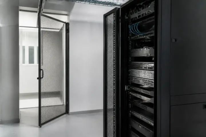 Salle technique d’une petite entreprise avec un serveur et des câbles réseau, éclairage sobre